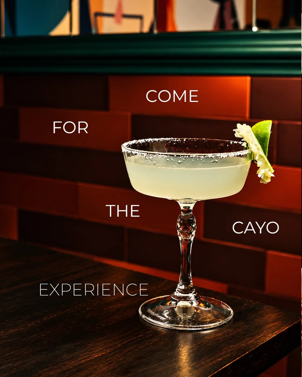 A salt-rimmed daiquiri on the bar counter against red brick