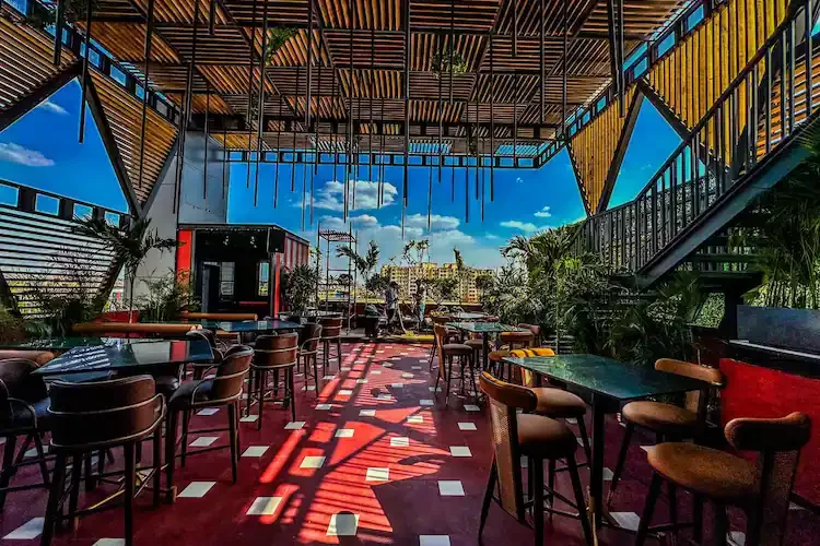 The open rooftop under the bamboo canopy, chandeliers hanging over marble tables