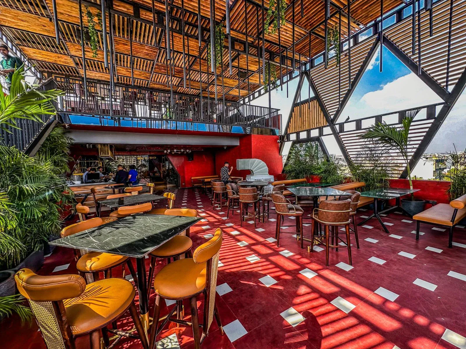 The CAYO rooftop at dusk — bamboo canopy, terrazzo floor and marble-topped bar tables