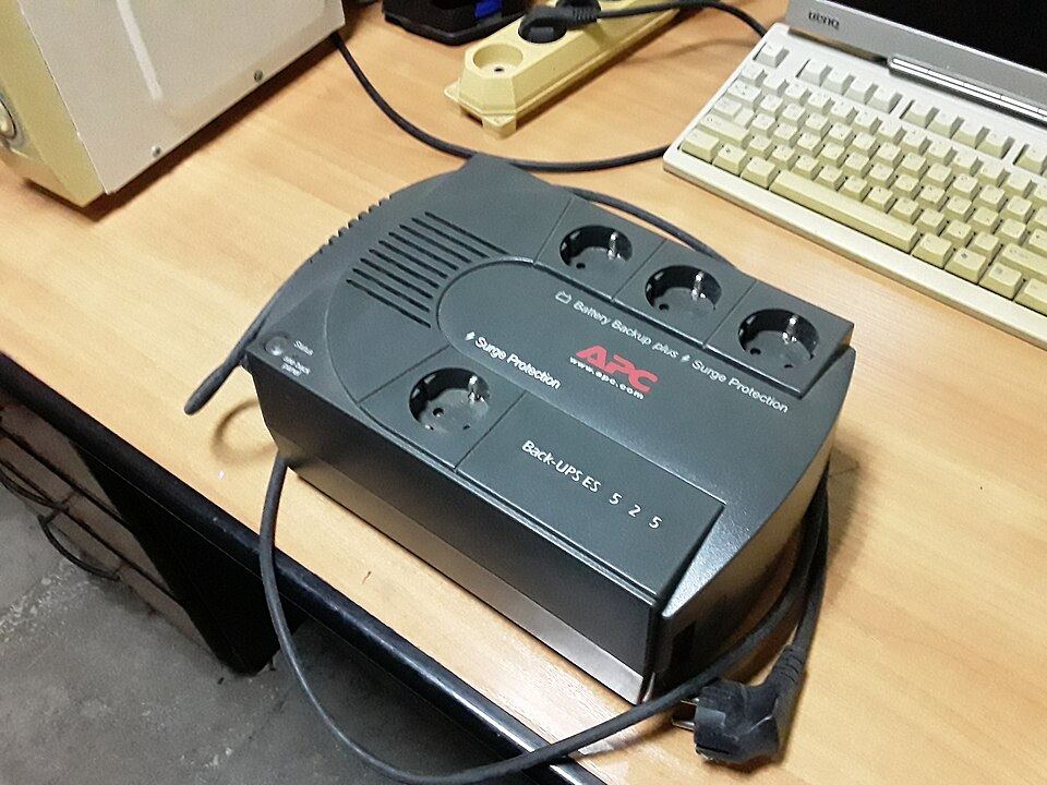 A UPS unit on a desk beside a keyboard